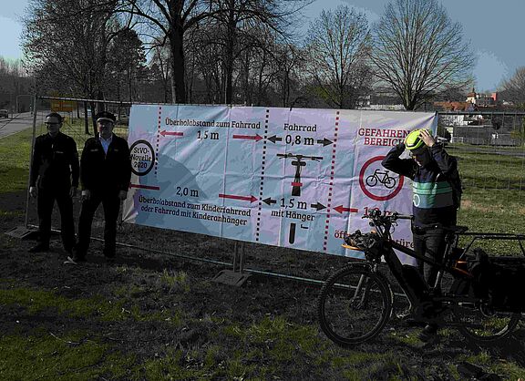 Banner weist auf vorgeschriebene Sicherheitsabstände beim Überholen hin