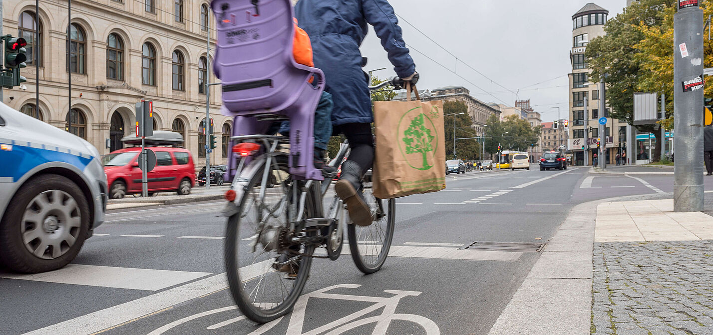 Fahrradfahren in der Stadt Frau mit Kind auf dem Rad in der Stadt unterwegs