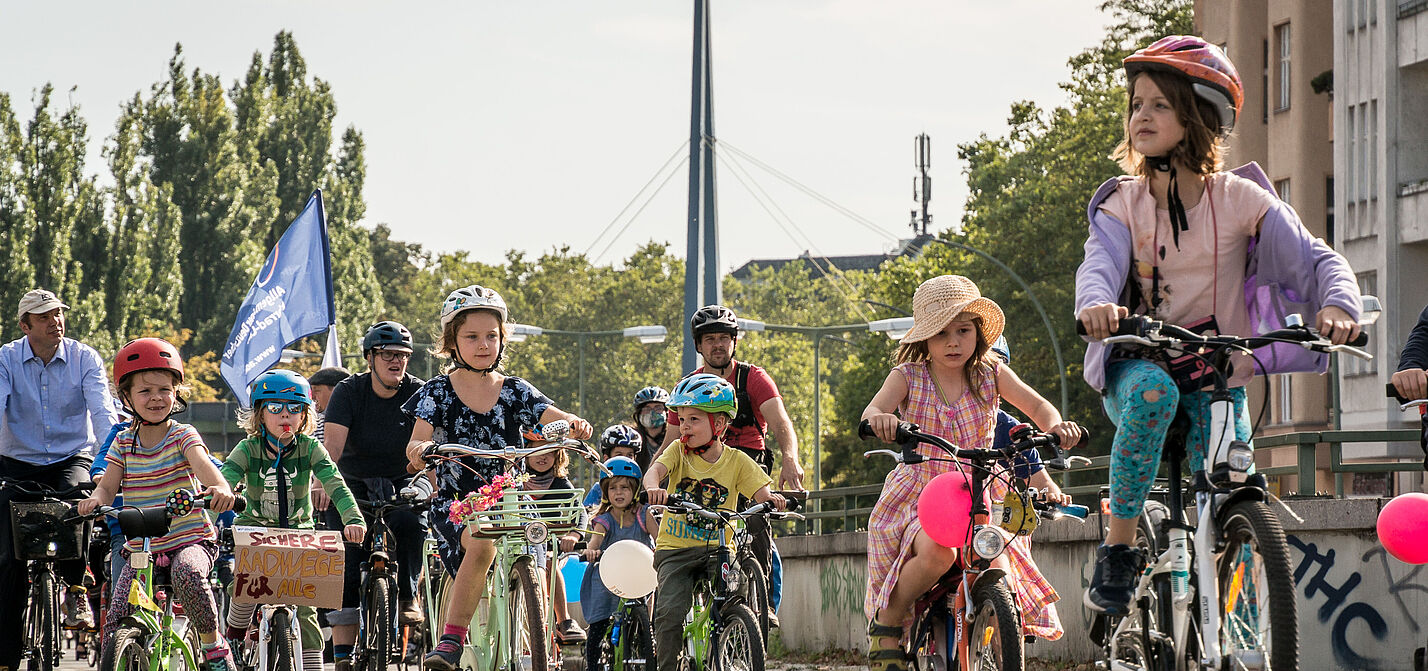 Kidical Mass in Berlin 2020 zahlreiche Kinder auf Fahrrädern mit Luftballons und Fahnen in Berlin